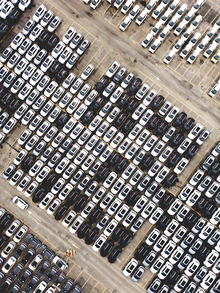heros-img Aerial perspective of a large car parking lot showcasing aligned vehicles in Brazil.